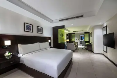 a bedroom with a large white bed and a living room at DoubleTree by Hilton Hotel Aqaba in Aqaba