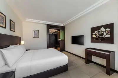 a bedroom with a white bed and a television at DoubleTree by Hilton Hotel Aqaba in Aqaba