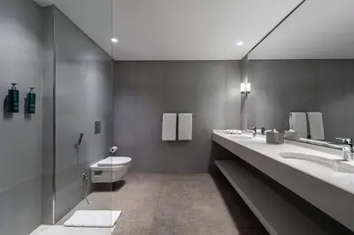 a bathroom with two sinks and a toilet in it at DoubleTree by Hilton Hotel Aqaba in Aqaba