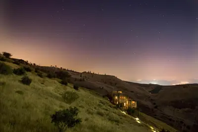 a house on top of a hill at night at Beit Al Fannan in Ţabaqat Faḩl