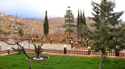 a garden with a fence and trees in a yard at Hayat Zaman Hotel And Resort Petra in Wadi Musa