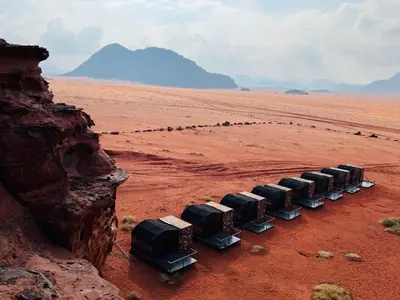 a group of trucks parked in the desert at Wadi Rum Shooting Stars Camp in Wadi Rum
