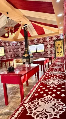 a room with red tables and red and white patterned walls at Wadi Rum experience in Wadi Rum