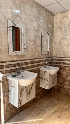 a bathroom with two sinks and two mirrors at Wadi Rum experience in Wadi Rum