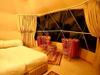 a bedroom with two chairs and a bed and a window at Wadi Rum experience in Wadi Rum