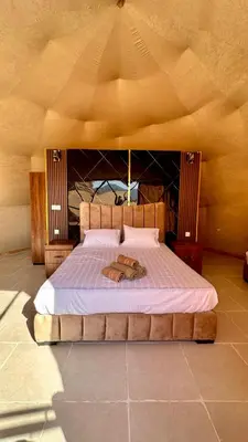 a bedroom with a large bed with a wooden headboard at Wadi Rum experience in Wadi Rum