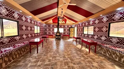 a room with red chairs and a stove in it at Wadi Rum experience in Wadi Rum