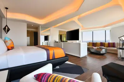 a bedroom with a bed and a living room at W Amman Hotel in Amman