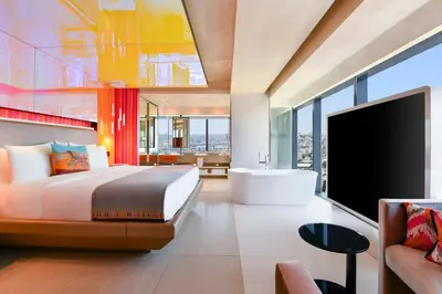 a bedroom with a king sized bed and a bath tub at W Amman Hotel in Amman