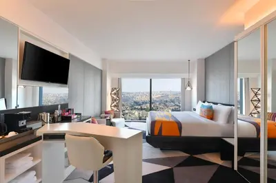 a hotel room with a bed and a desk with a desk at W Amman Hotel in Amman