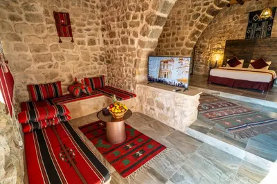 a room in a castle with a bed and pillows at The Old Village Hotel & Resort in Wadi Musa