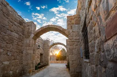 an archway in an alley between two stone buildings at The Old Village Hotel & Resort in Wadi Musa