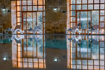 a swimming pool with chairs in a building at The Old Village Hotel & Resort in Wadi Musa