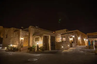 a stone building with lights at night at The Old Village Hotel & Resort in Wadi Musa