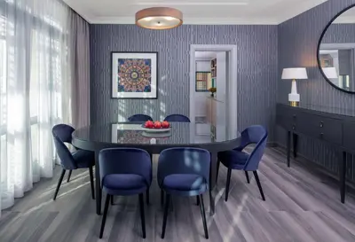 a dining room with a black table and blue chairs at Grand Hyatt Amman in Amman