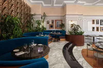 a restaurant with blue couches and tables and plants at Grand Hyatt Amman in Amman