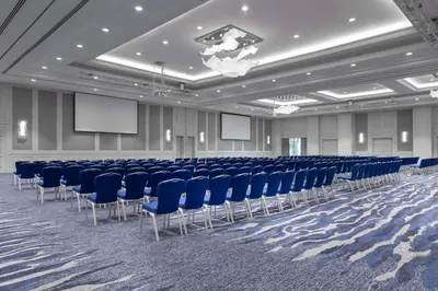 a conference room with blue chairs and screens at Grand Hyatt Amman in Amman