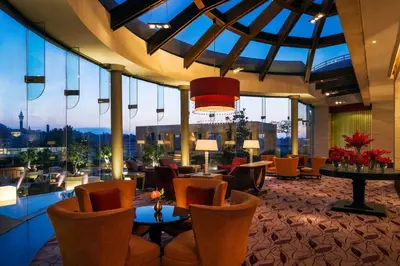 a hotel lobby with chairs and tables and windows at Grand Hyatt Amman in Amman