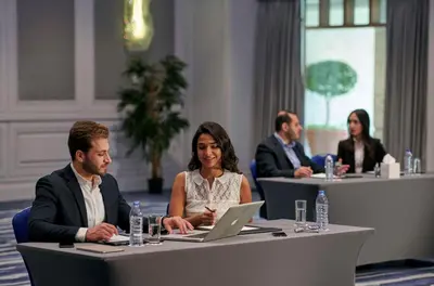 a group of people sitting at a table with a laptop at Grand Hyatt Amman in Amman