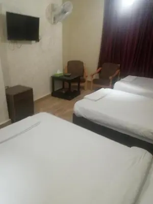 a hotel room with two beds and a flat screen tv at Al-Houriat Hotel in Amman