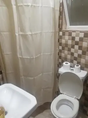 a bathroom with a white toilet and a sink at Al-Houriat Hotel in Amman