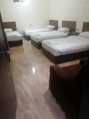 a room with four beds in a room at Al-Houriat Hotel in Amman