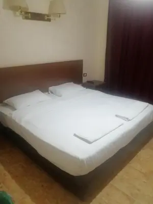 a large white bed sitting in a room at Al-Houriat Hotel in Amman