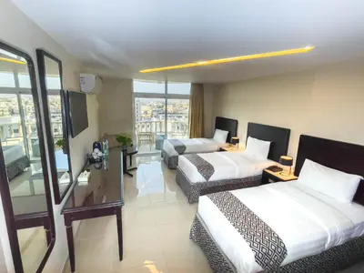 a hotel room with two beds and a balcony at Dweik Hotel 2 in Aqaba