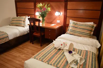 a hotel room with two beds and a desk at Comfort Hotel Suites in Amman