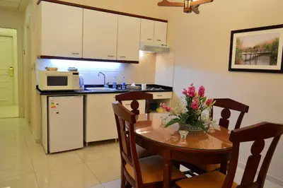a kitchen with a table with chairs and a microwave at Comfort Hotel Suites in Amman