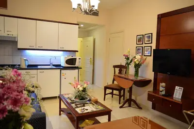 a kitchen and a living room with a table at Comfort Hotel Suites in Amman