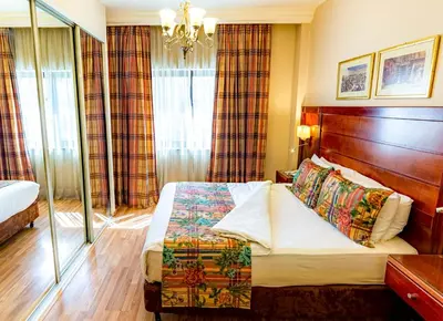 a hotel room with a bed and a chandelier at Comfort Hotel Suites in Amman