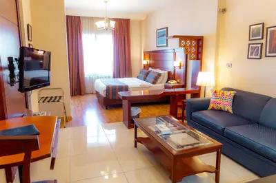 a living room with a couch and a bed at Comfort Hotel Suites in Amman