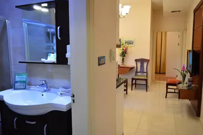 a bathroom with a white sink and a room at Comfort Hotel Suites in Amman