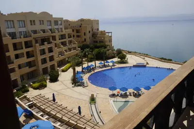 a view of a swimming pool with umbrellas and chairs at Apartment Samarah Resort Sea & Pool view D in Sowayma