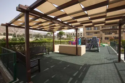 a pavilion with benches and a playground in a park at Apartment Samarah Resort Sea & Pool view D in Sowayma
