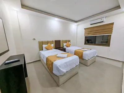a hotel room with two beds and a television at Petra Gate Hotel in Wadi Musa