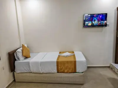 a bedroom with a bed with a tv on the wall at Petra Gate Hotel in Wadi Musa