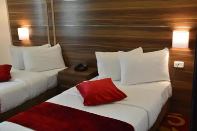 a hotel room with two beds with white and red pillows at Spark Plaza Hotel in Amman