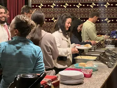 a group of people standing in a kitchen preparing food at Bedouin Nights Camp in Wadi Rum