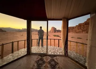 a man standing on a balcony looking out at the desert at Joy to Wadi Rum in Wadi Rum