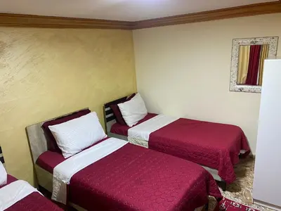 two beds in a room with red and white sheets at Al-Amer Aqaba Beach Hostel in Aqaba