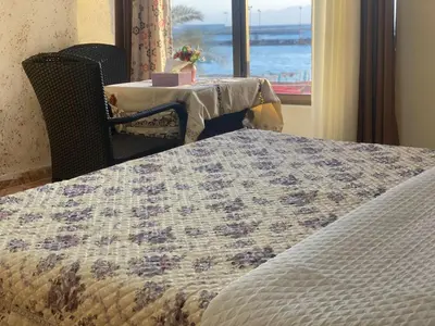 a bedroom with a bed and a table and a window at Al-Amer Aqaba Beach Hostel in Aqaba