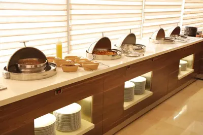 a buffet with plates and pans of food at Lacosta Hotel in Aqaba
