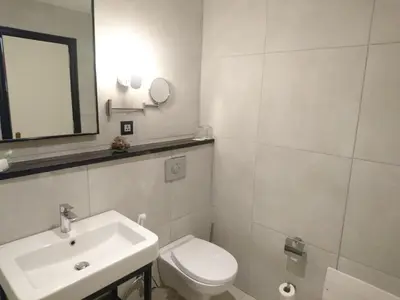 a bathroom with a sink and a toilet and a mirror at The Conroy Boutique Hotel in Amman