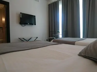 a hotel room with two beds and a tv on the wall at The Conroy Boutique Hotel in Amman