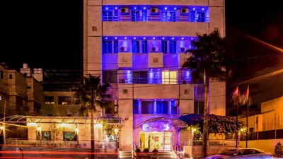 a building with blue lights on it at night at Aghadeer Hotel in Amman