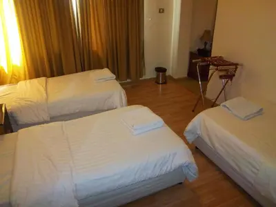 a hotel room with two beds with white sheets at Aghadeer Hotel in Amman