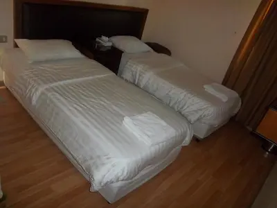two beds sitting next to each other in a bedroom at Aghadeer Hotel in Amman