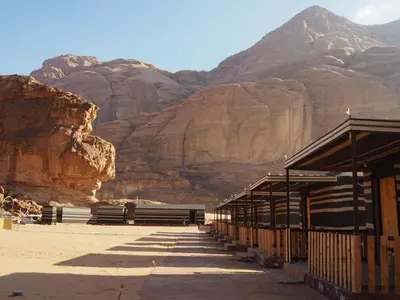 a building in the desert with mountains in the background at Salman Zwaidh Camp in Wadi Rum